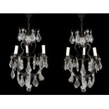 A pair of metal and cut glass hung three light chandeliers in Louis XV style, of recent manufacture,