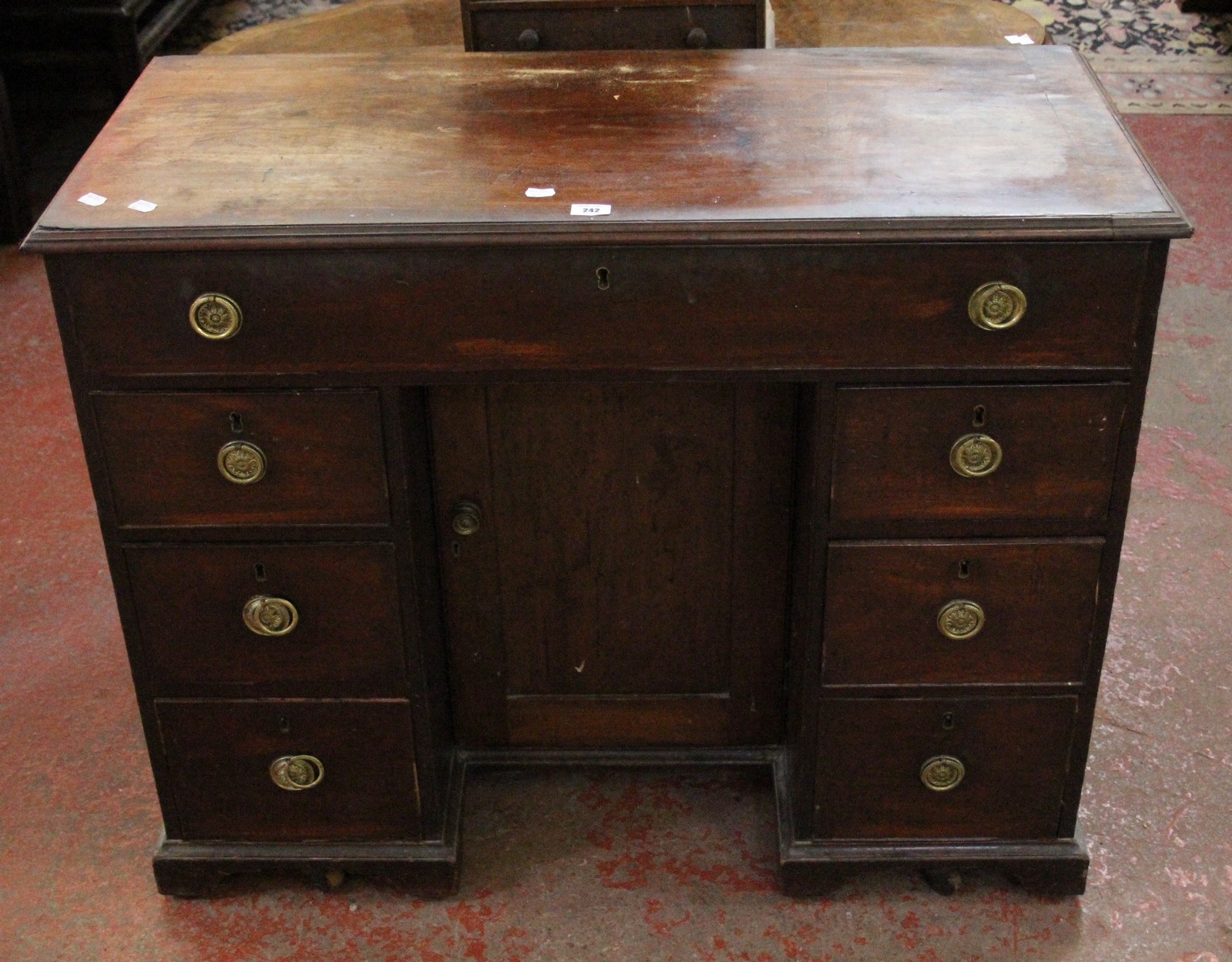 A 19th Century mahogany kneehole desk with one long drawer and six short drawers flanking central