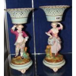 Pair of French porcelain comports, male and female figures, each with pierced basket, on circular