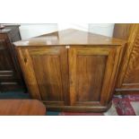 A walnut corner cupboard, circa 1900 with a pair of panelled cupboard doors 107cm high, 135cm