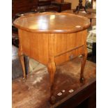 A 1930's walnut sewing table with a hinged top.