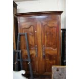 A large18th century Normandy cherrywood armoire with moulded cornice and panelled doors raised on