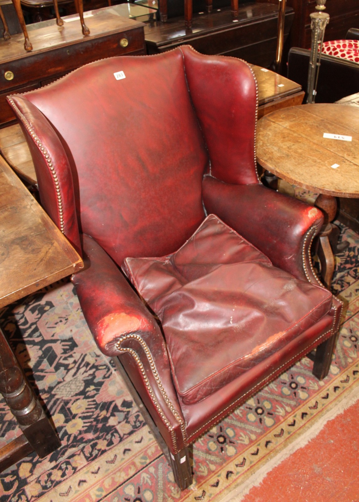 A leather wing armchair in George III style (20th century).