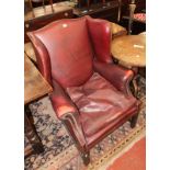 A leather wing armchair in George III style (20th century).