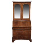 A George II walnut and featherbanded bureau bookcase, circa 1735  A George II walnut and