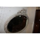 A Victorian style white painted oval mirror with a ribbon surmount 70cm high, 83cm wide