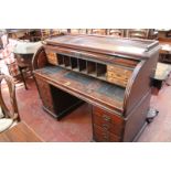 A Victorian mahogany roll top desk, with fitted interior, pull out writing desk and eight short