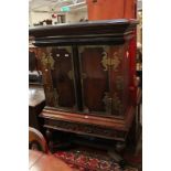 A 19th century Dutch Colonial cabinet on stand with intricate brass overlay to the doors.