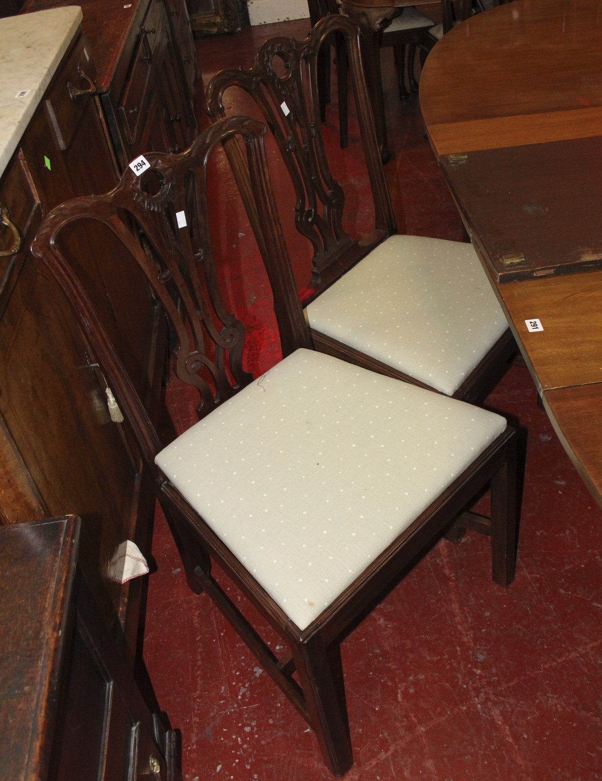 A set of George III style mahogany dining chairs each with a carved toprail and pierced splat and