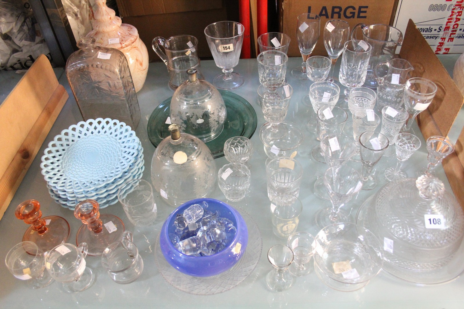 An assortment of glassware to include wines, vases, decanter stoppers and a colour print of still