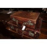 Two crocodile suitcases, the larger 61 x 41cm