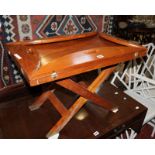 A modern butlers tray on a folding stand and a pair of small bedside tables