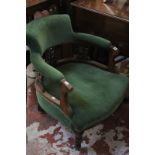 A Victorian bow back armchair upholstered in green fabric.