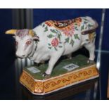 A Dutch Delft model of a polychrome cow, on a shaped rectangular base, circa 1900