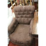 A brown upholstered armchair on turned legs