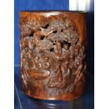 A Chinese carved brush pot, with relief of figures in a landscape, 17cm high