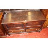 An oak mule chest, with a hinged lid and panelled front, two frieze drawers on shaped feet 127cm