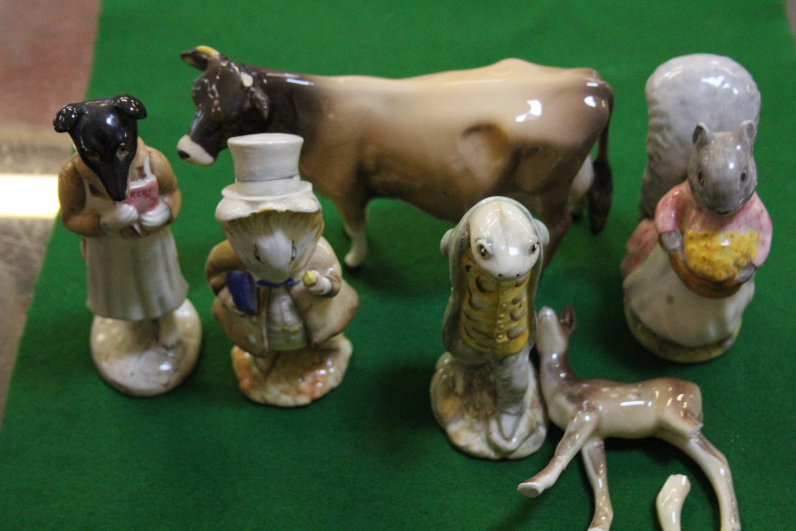 Beswick model of a cow, four Beswick Beatrix Potter figures and a model of a faun (with broken