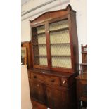 A William IV mahogany secretaire, with a shaped cornice, the brass work doors enclosing shelves