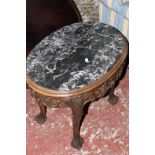 An oval marble top table on a mahogany base and a brass tray top table on a brass scrolled base.