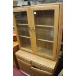 A modern Ercol cabinet on base, the whole on castors