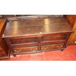 An oak mule chest, with a hinged lid and panelled front above two frieze drawers and on shaped