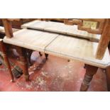 An early 20th century pine extending kitchen table the top with moulded edge above four turned