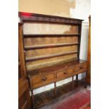 An early 19th century oak Welsh dresser the moulded cornice and hooks above three plate shelves