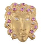 A pink sapphire and diamond mask brooch by Rinaldi  A pink sapphire and diamond mask brooch by