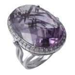 An amethyst and diamond ring, the oval shaped amethyst claw set within a...  An amethyst and diamond