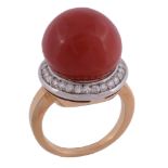 A coral and diamond ring, the 14.2mm coral within a surround of brilliant...  A coral and diamond