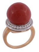 A coral and diamond ring, the 14.2mm coral within a surround of brilliant...  A coral and diamond