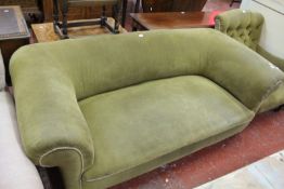 An Edwardian sofa with scroll arms and back on turned legs, brass caps, and castors