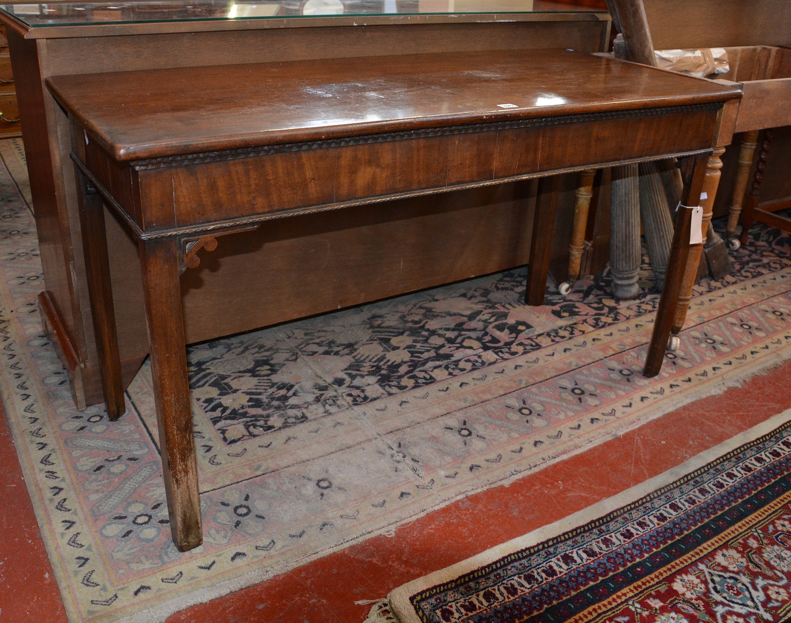 A George III mahogany serving table on chamfered supports.