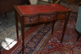 A serpentine front writing table in the Georgian style.