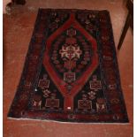A Middle Eastern carpet with lozenge shaped central medallion predominately red and blue, 230cm x