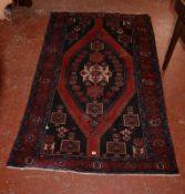 A Middle Eastern carpet with lozenge shaped central medallion predominately red and blue, 230cm x