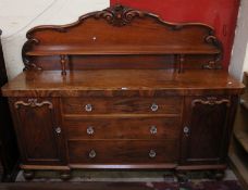 A William IV mahogany side cabinet, circa 1835, the carved superstructure with a shelf, above