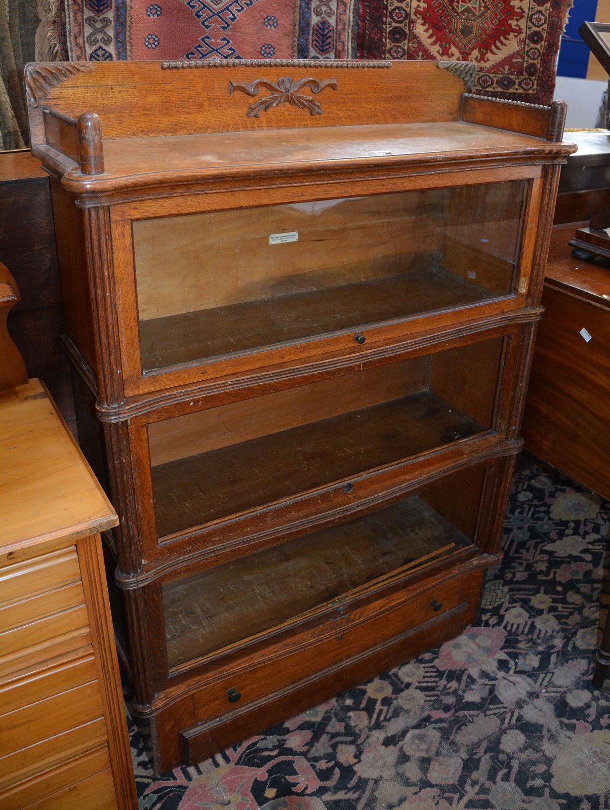 A Globe Wernicke three section bookcase with drawer to plinth base 130cm high, 90cm wide, 32cm