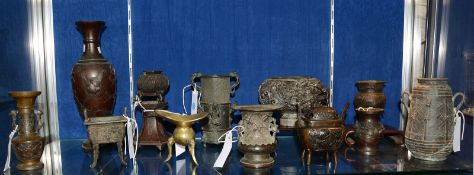 An assortment of twelve late 19th Century Chinese and Japanese bronze vases and two wooden stands