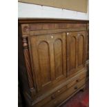 An early 19th century Welsh oak side cupboard, with a pair of arched panelled doors and flanking