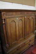 An early 19th century Welsh oak side cupboard, with a pair of arched panelled doors and flanking