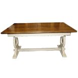 An oak refectory table with a painted trestle base, used for shop display.