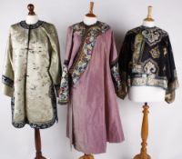 A late 19th century Chinese women's black silk jacket, embroidered with flowers and motifs, the