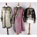 A late 19th century Chinese women's black silk jacket, embroidered with flowers and motifs, the
