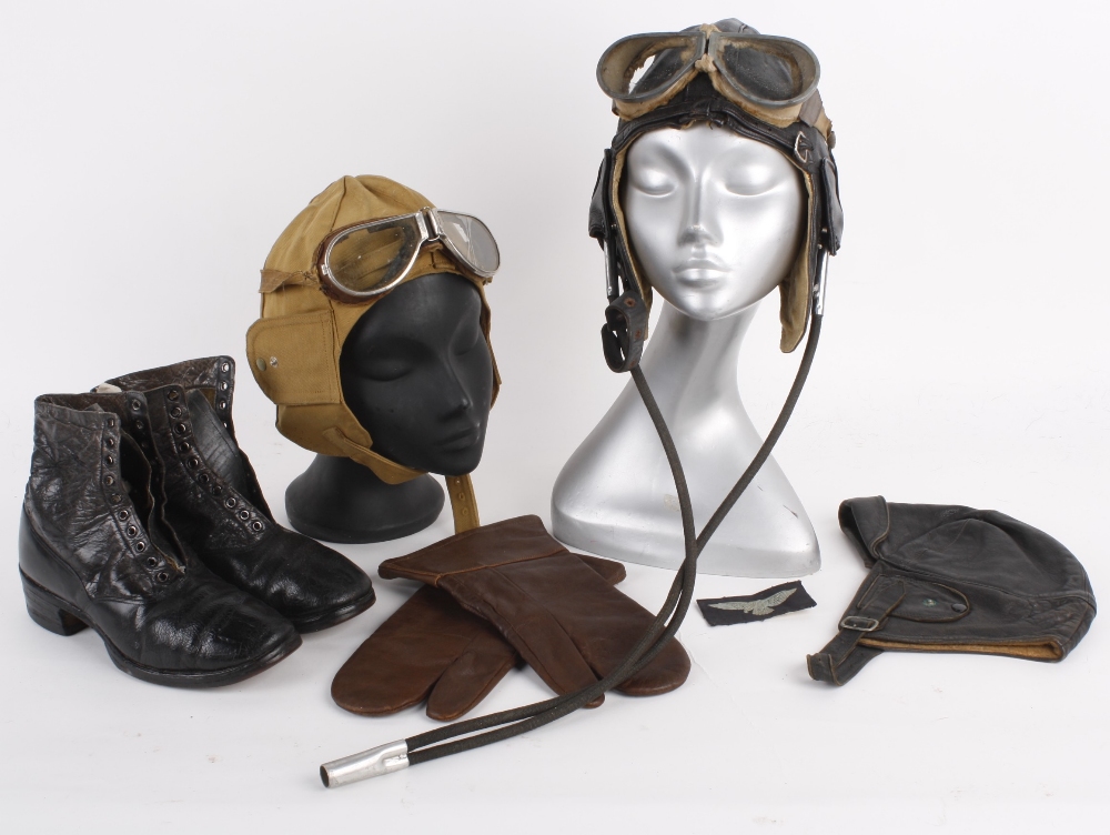 A leather flying helmet with two pairs of flying goggles and a badge; together with a black