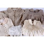 A quantity of children's costume, comprising: three early 20th century coats; a smocked linen dress;