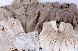 A quantity of children's costume, comprising: three early 20th century coats; a smocked linen dress;