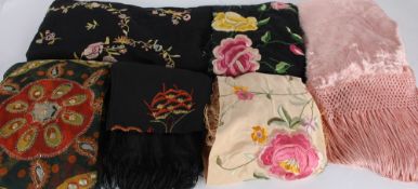 A dusky pink throw with a fringe; together with a black silk fringed shawl; an apricot embroidered