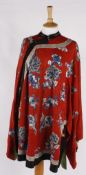 An early 20th century Chinese red silk jacket, embroidered with flowers worked in shades of blue and